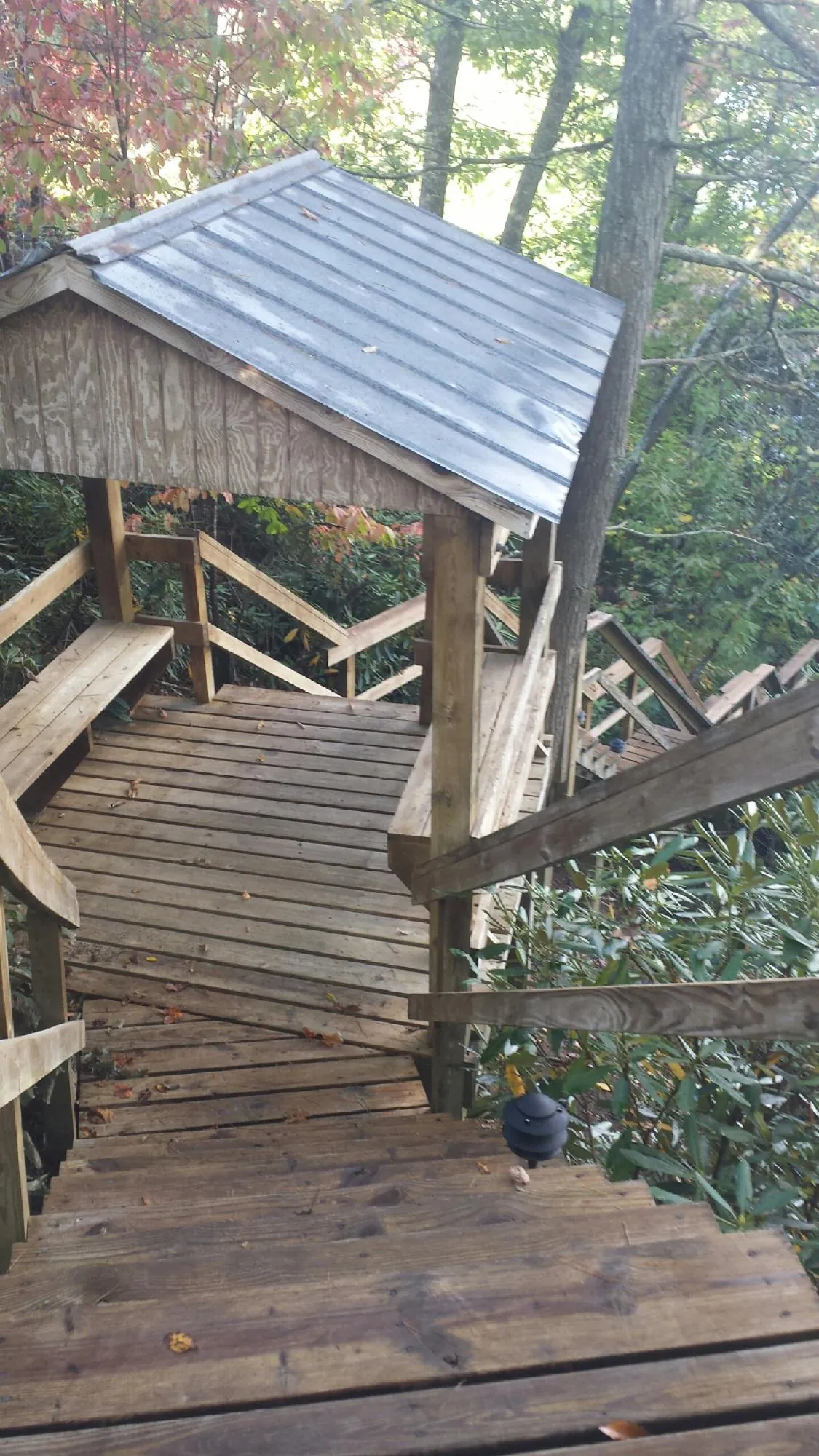 Metal roofed shelter over wooden steps on a wooded walkway — Skylight Repair & Installation work by our crew in Hanover
